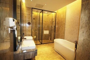 A modern bathroom with a glass-enclosed shower, a white bathtub, and a marble vanity with a mirror.