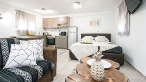 Eine moderne Wohnung mit Küchenzeile, Essbereich und Schlafzimmer.