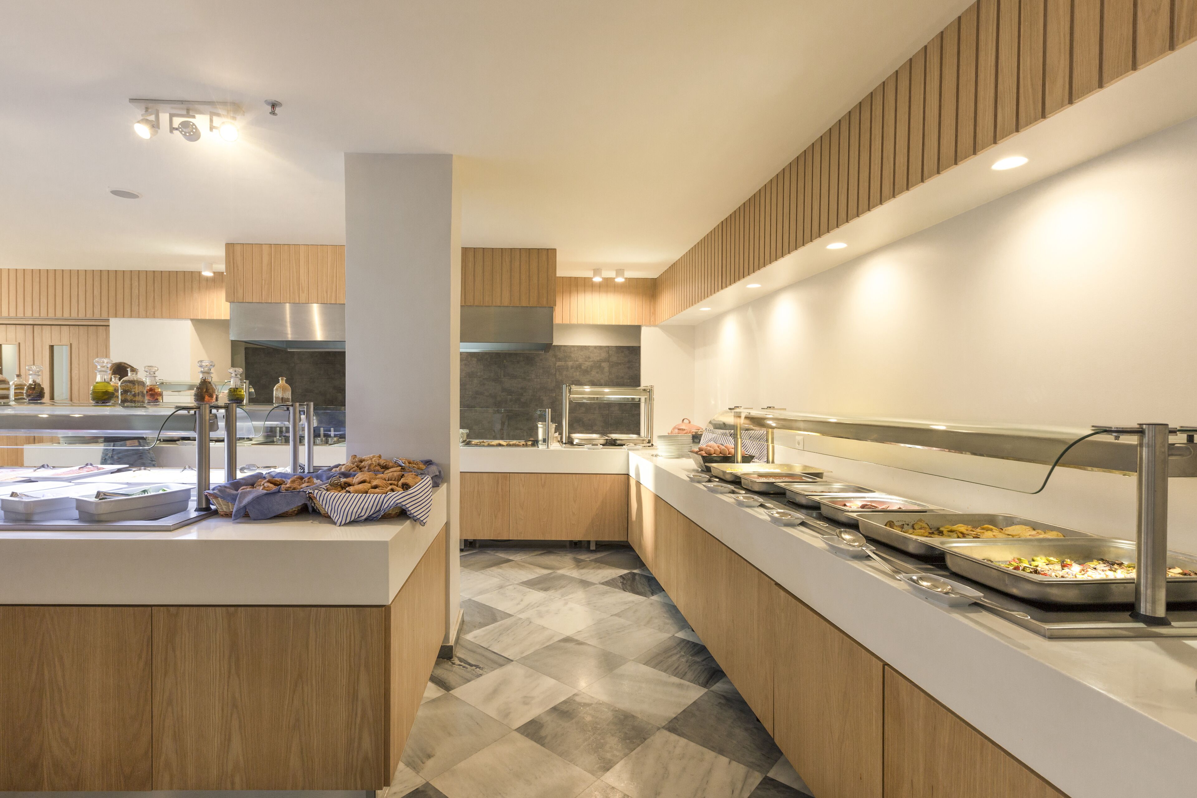 A modern kitchen with a central island, wooden cabinets, and a checkered floor.