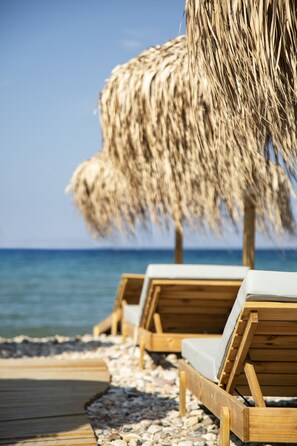 A wooden deck with lounge chairs and a thatched umbrella. - Erato by Samian Mare (Samos)