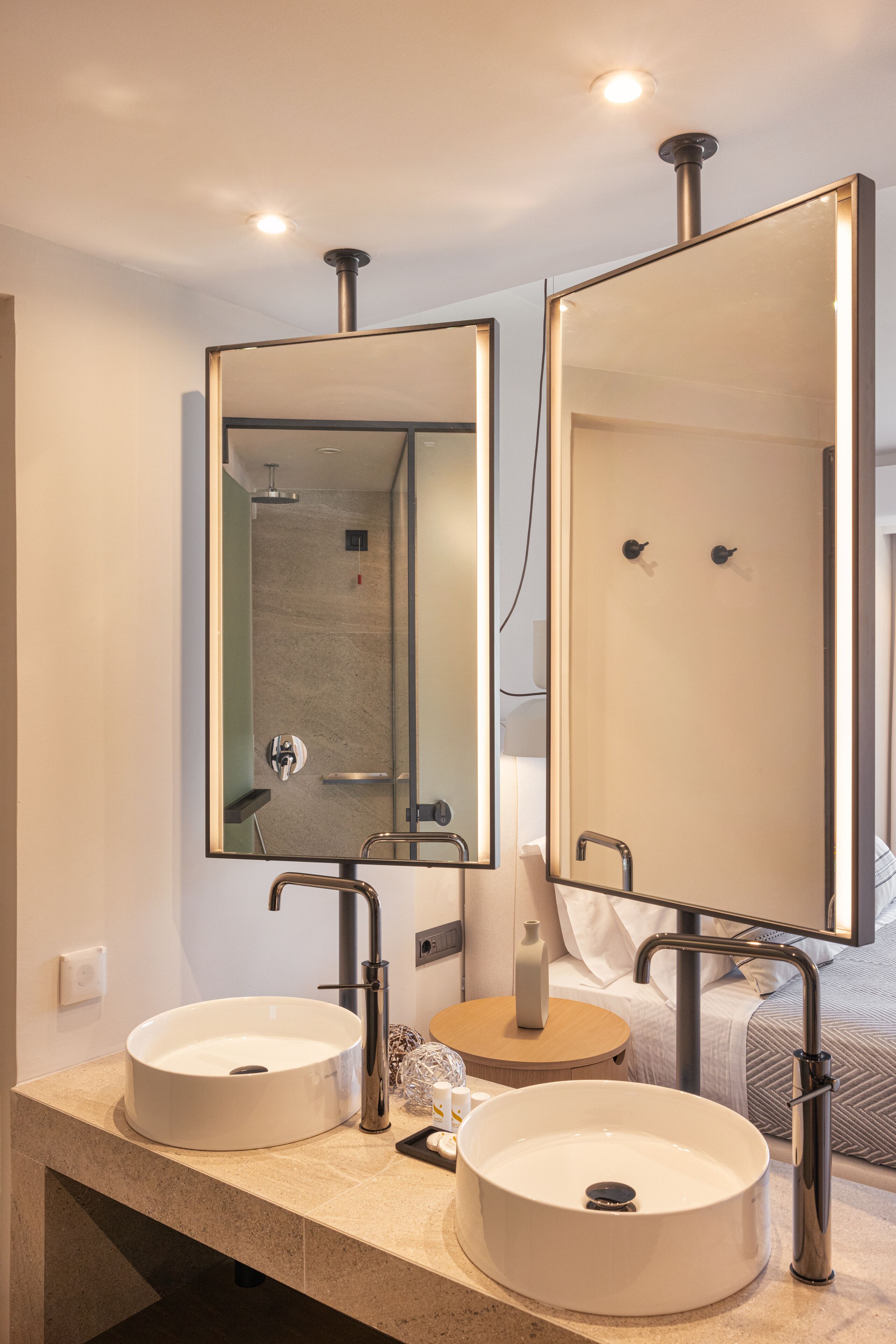 Une salle de bain moderne avec deux lavabos, un grand miroir et une douche.