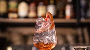 A bar setting with a cocktail glass, ice cubes, and a bar tool.