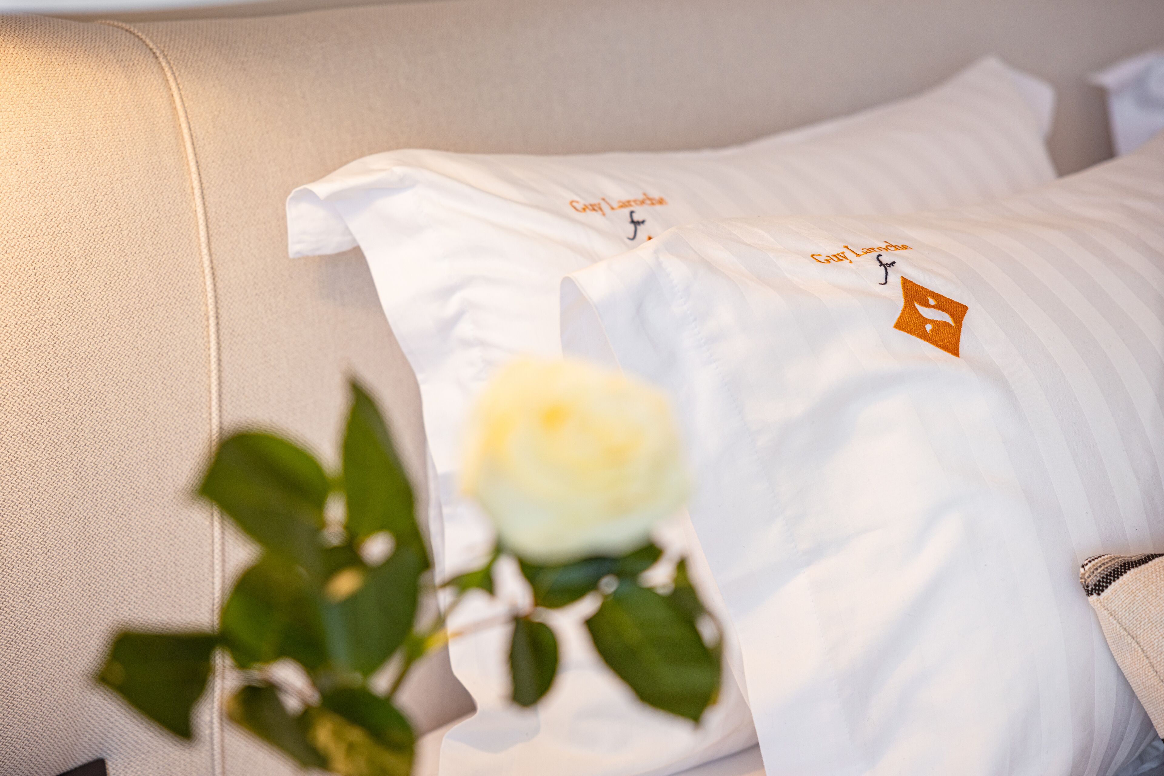 A bed with white pillows and a tag that reads "Gary Lamont."