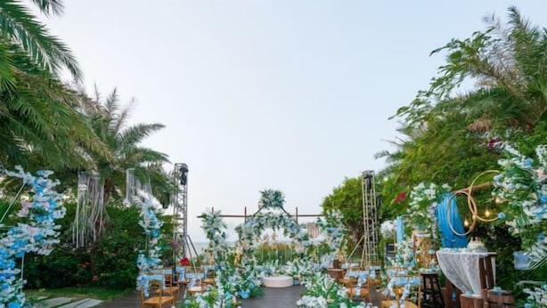 An outdoor wedding venue with a wooden deck, floral decorations, and seating arrangements. - Vaikuha Seaview Hotel (Beihai)
