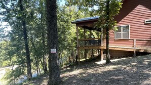 A wooden cabin with a deck, surrounded by trees and a private property sign. - Relax and Unwind on the Caddo River in Beautiful Arkansas! Book now! (Amity)