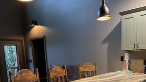 A kitchen with a marble countertop, wooden chairs, and green cabinets. - Relax and Unwind on the Caddo River in Beautiful Arkansas! Book now! (Amity)