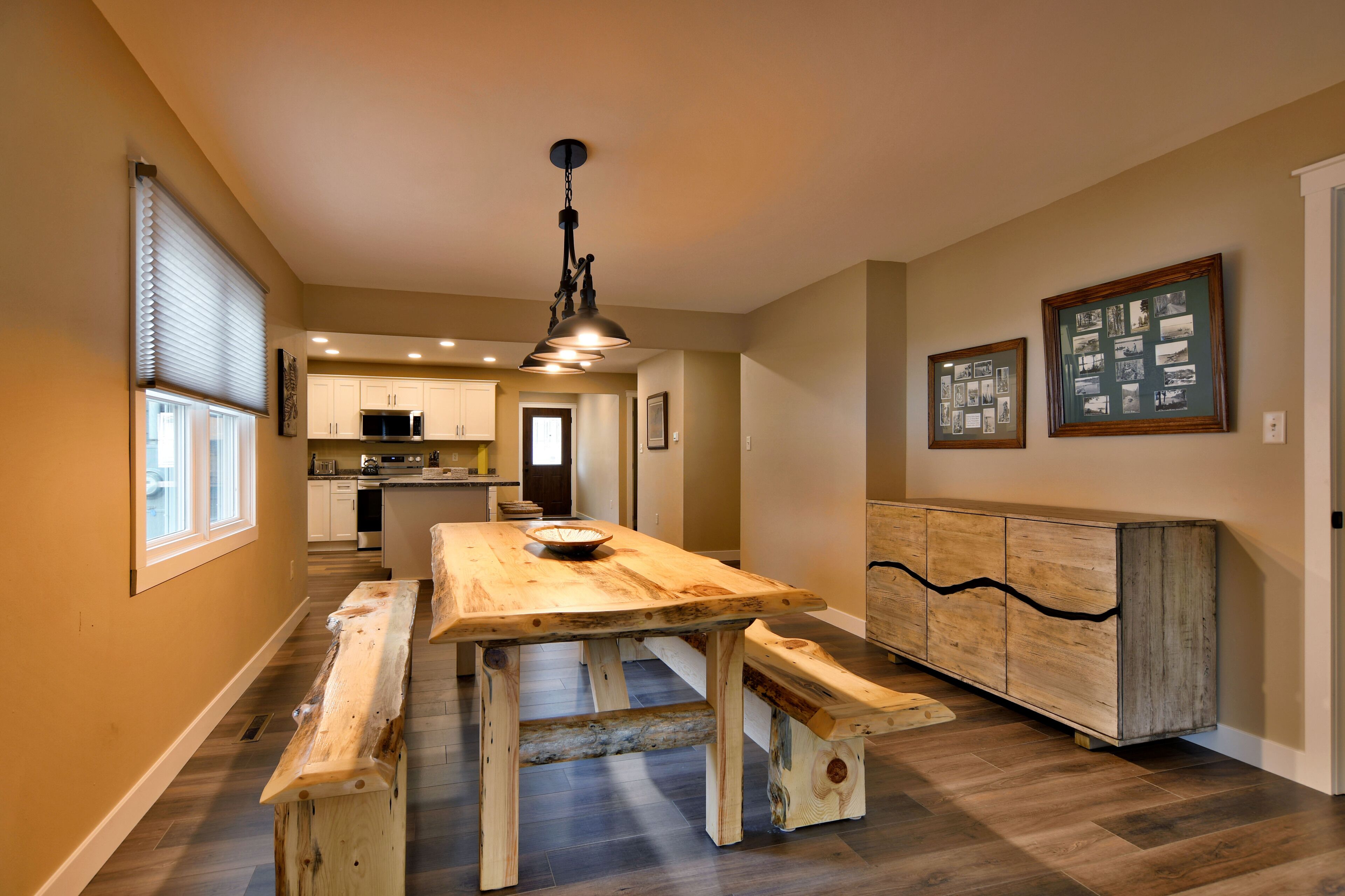 Une cuisine spacieuse dotée de plans de travail en bois, d’un îlot central et d’un luminaire suspendu.