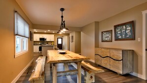 Una cocina amplia con encimeras de madera, una isla central y una lámpara colgante.