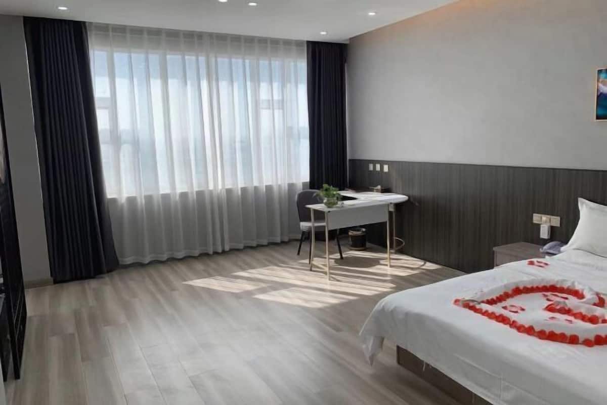 A hotel room with a bed, a desk, and a chair.