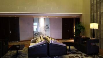 A lobby with a sofa set, a coffee table, and a lamp.