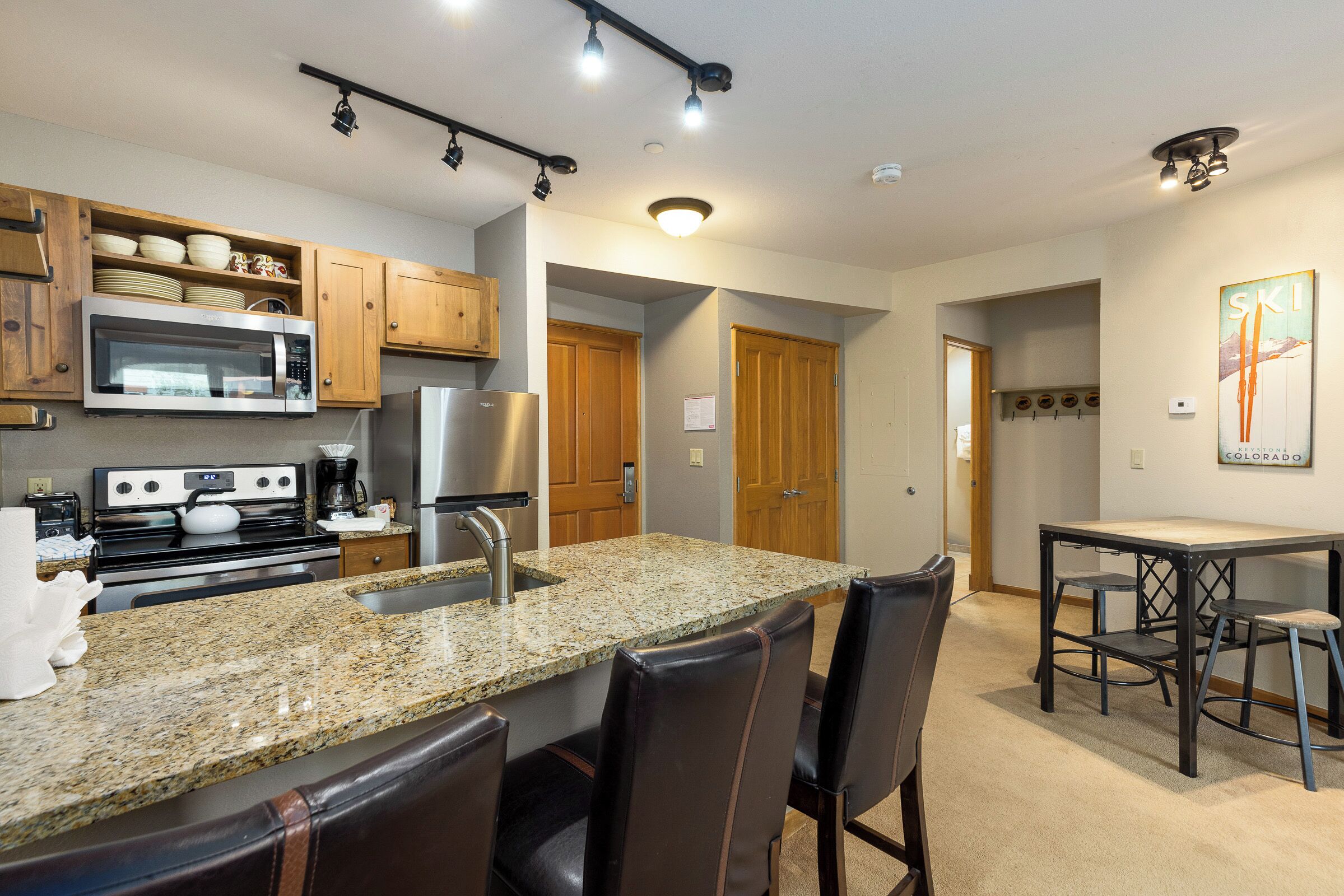 A modern kitchen with granite countertops, stainless steel appliances, and wooden cabinets.