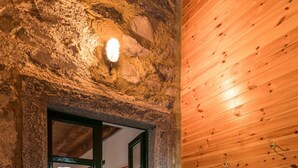 A rustic interior with a stone wall, a wooden door, and a wooden panel wall. - Il Faggio by Wonderful Italy (Bellagio)