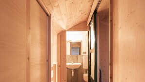 A wooden interior hallway leading to a bathroom with a sink and toilet. - Il Faggio by Wonderful Italy (Bellagio)
