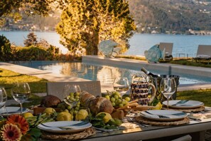 A table set for a meal with a view of a lake and mountains. - Villa Bianca (San Felice del Benaco)