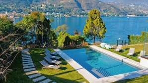 A swimming pool with a clear view of a lake and mountains in the background. - Villa Bianca (San Felice del Benaco)
