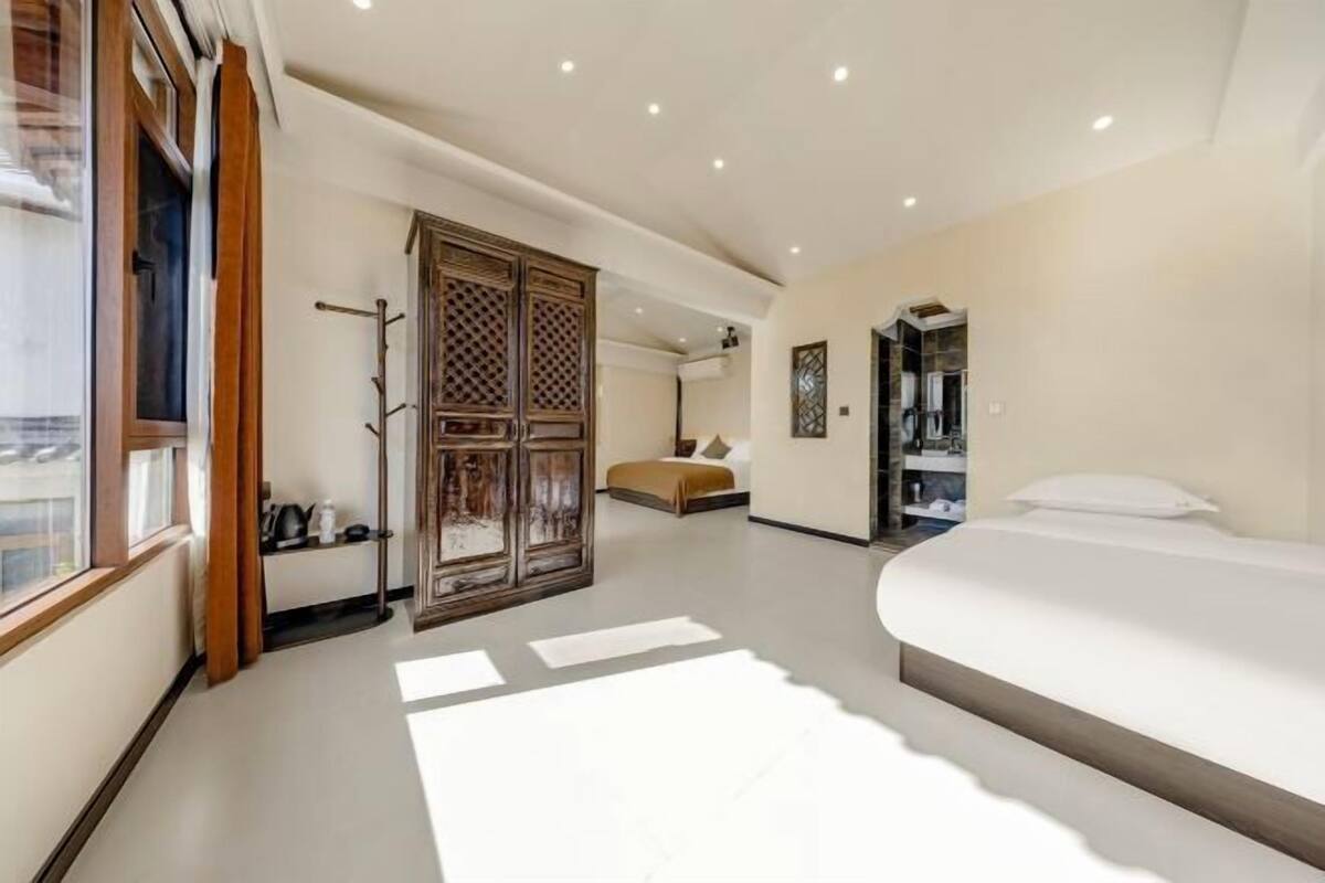 Un dormitorio con una cama grande, un armario y un espejo.