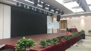 A conference room with a stage, a whiteboard, and potted plants. - Magnotel Hotel (Weinan Duhua Road Haixing City) (Weinan)