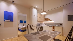Ett modernt hotellrum med en matplats, ett kök och ett badrum.