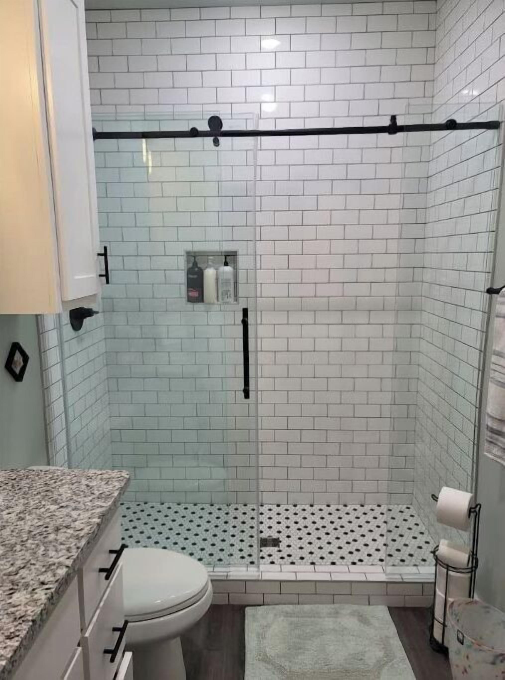 A bathroom with a shower, toilet, and sink.