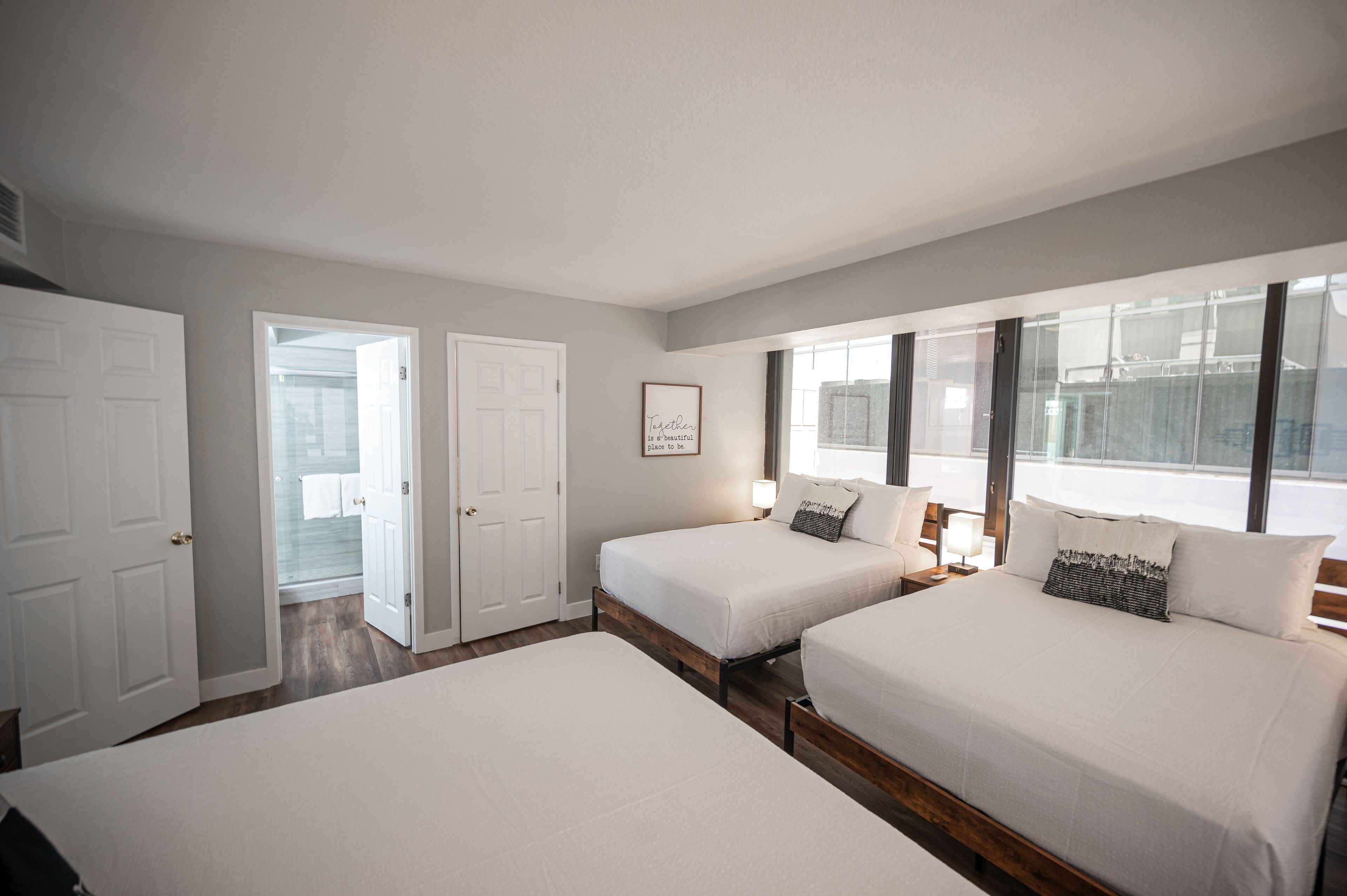 Una habitación de hotel con dos camas, una ventana y una puerta que da a un baño.