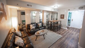 A living room with a leather sofa, a coffee table, and a dining area with a table and chairs. - Stay Together Suites | Strip Condo PH (Las Vegas)
