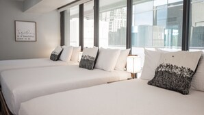 A hotel room with two beds, large windows, and a framed quote on the wall. - Stay Together Suites | Strip Condo PH (Las Vegas)