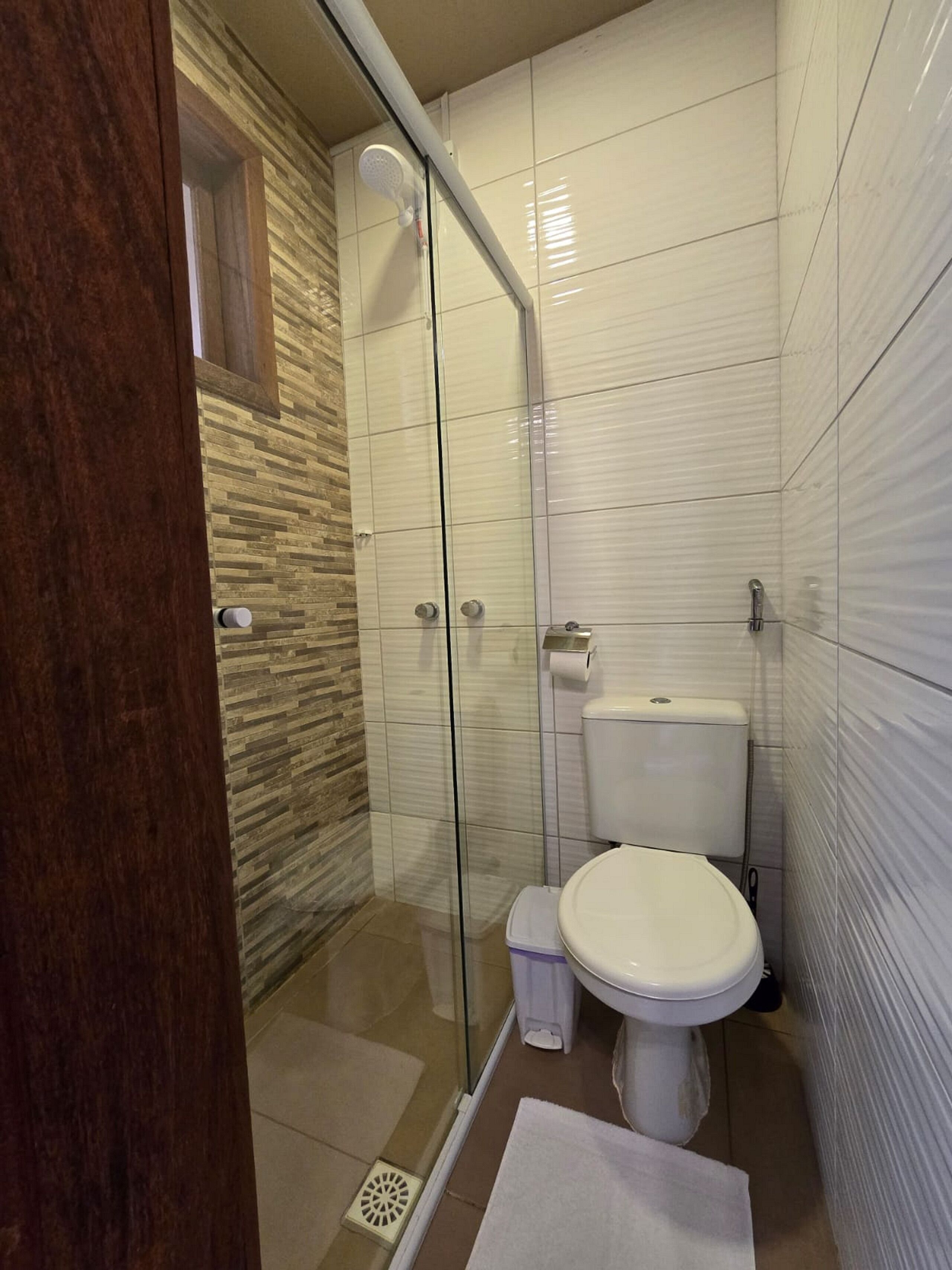 Un baño moderno con cabina de ducha de vidrio, inodoro y bidé.