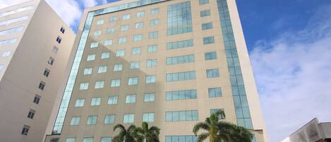 Un moderno edificio de hotel con fachada color crema y numerosas ventanas.