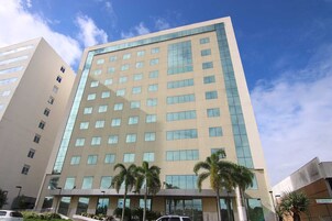 Edifício moderno de hotel com fachada bege e várias janelas.