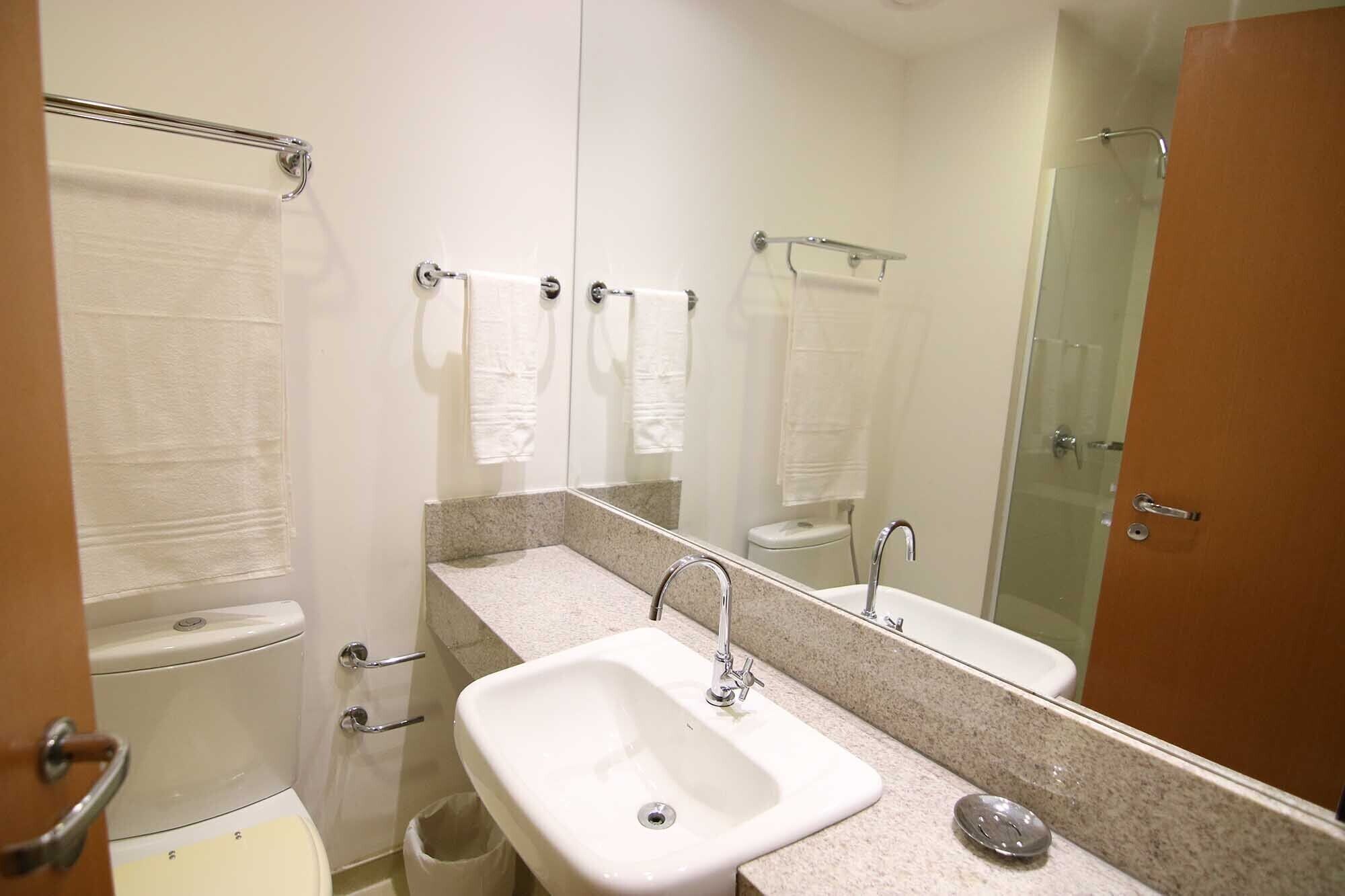 A bathroom with a sink, mirror, and a shower area.