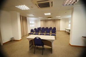 A conference room with a long table, multiple chairs, and a small table in the background. - Samba Linhares (Linhares)