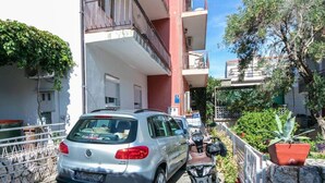 Un'auto argentata parcheggiata di fronte a un edificio con un balcone.