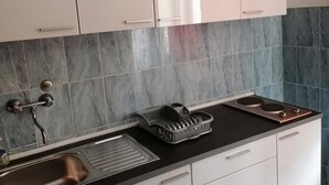 Una cucina con mobili bianchi, un piano di lavoro nero e un lavello in acciaio inossidabile.