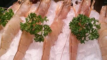 A display of shrimp on ice with parsley garnish.
