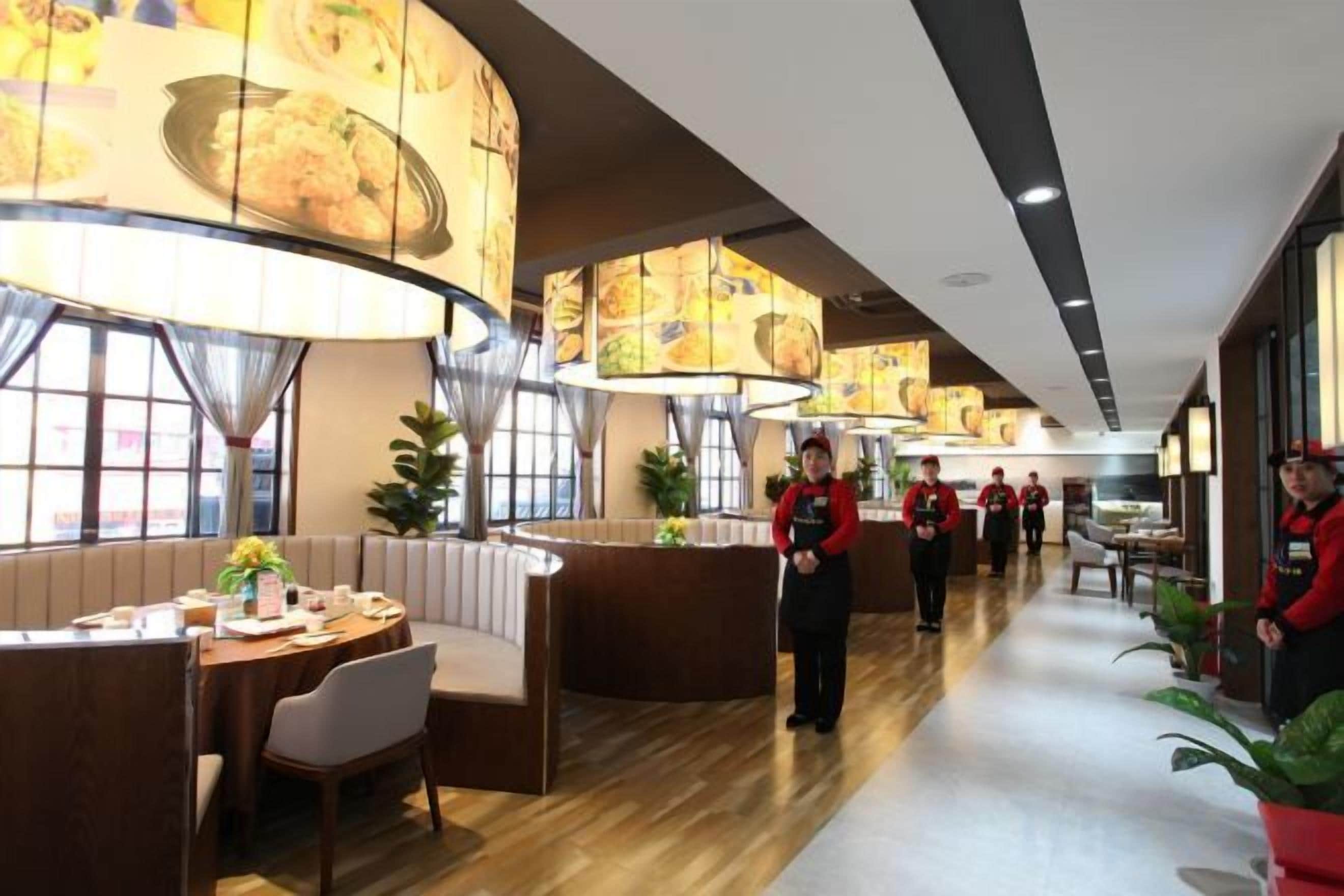 A restaurant with booths, a long counter, and staff in red uniforms.