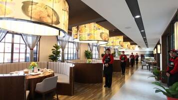 A restaurant with booths, a long counter, and staff in red uniforms.