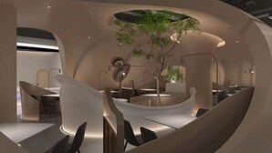 A modern interior with curved seating areas and a central plant. - Longchang Holiday Hotel (Tang County)