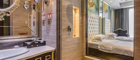A modern bathroom with a large mirror, vanity, and a glass shower enclosure.