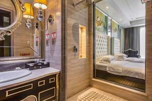A modern bathroom with a large mirror, vanity, and a glass shower enclosure.