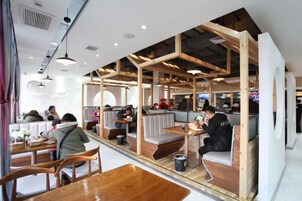 A restaurant with wooden booths, tables, and a modern interior design.
