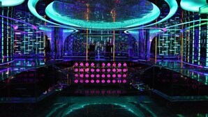 A futuristic interior with a central stage, neon lights, and a reflective floor. - Longchang Holiday Hotel (Tang County)