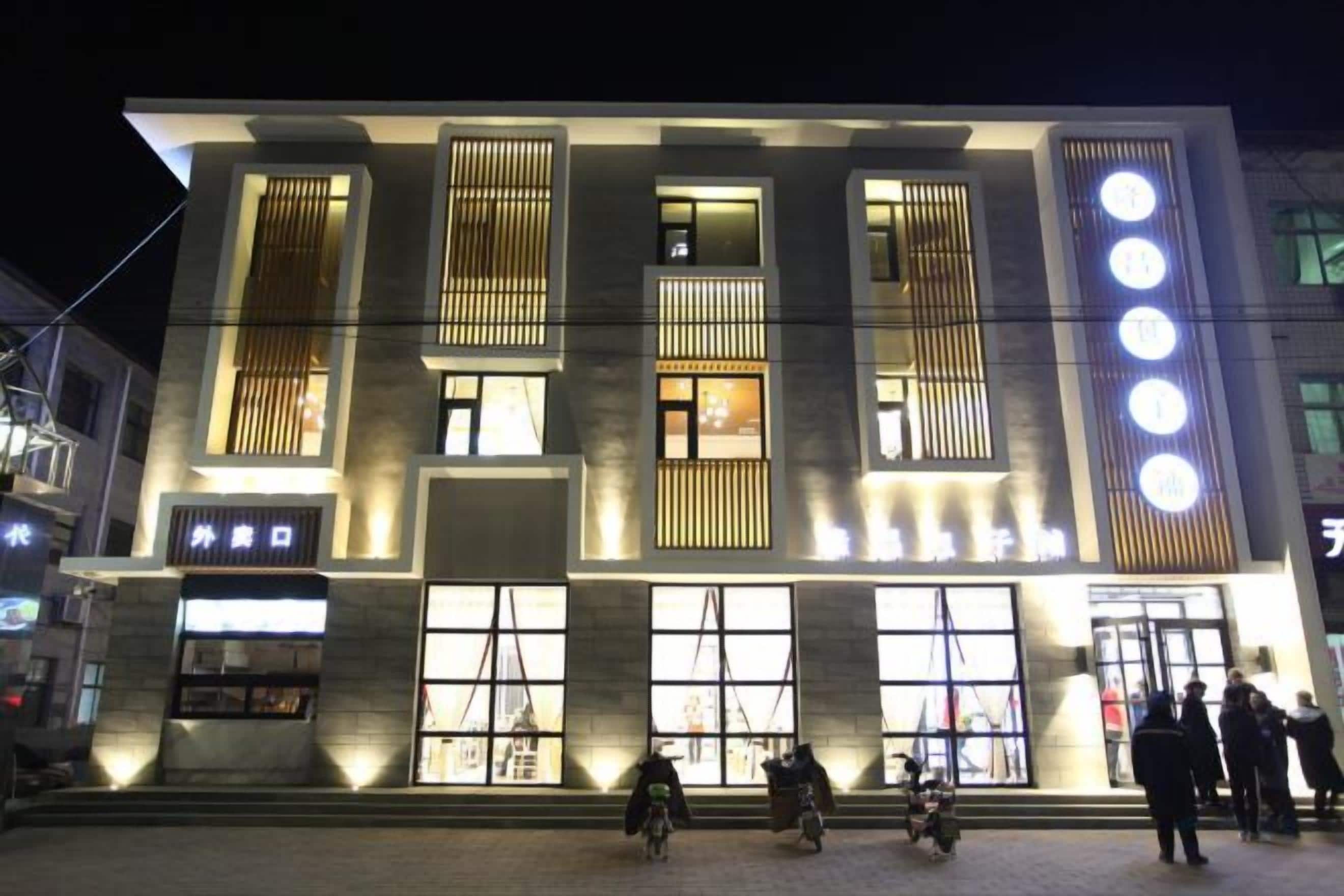 Un edificio moderno con ventanas amplias y una entrada destacada.