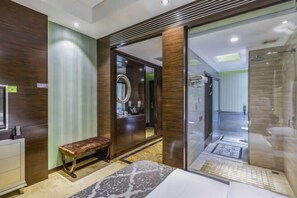 A modern bathroom with a glass shower enclosure, a bench, and a vanity with a mirror. - Longchang Holiday Hotel (Tang County)