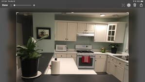 A modern kitchen with white cabinets, a black countertop, a microwave, a stove, and a sink. - Hatteras Village *** Southside 3 *** (Hatteras)