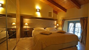 A bedroom with a large bed, two bedside tables with lamps, a mirror, and a window with curtains. - THE WAVE :: APARTMENT (Lezzeno)