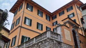 A multi-story building with a stone facade and green shutters. - THE WAVE :: APARTMENT (Lezzeno)