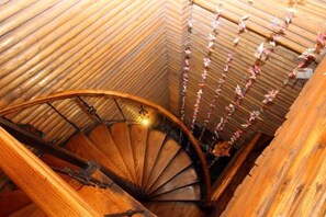 A spiral staircase with a wooden handrail and a wooden ceiling. - A Good Year (Fenghuang County)