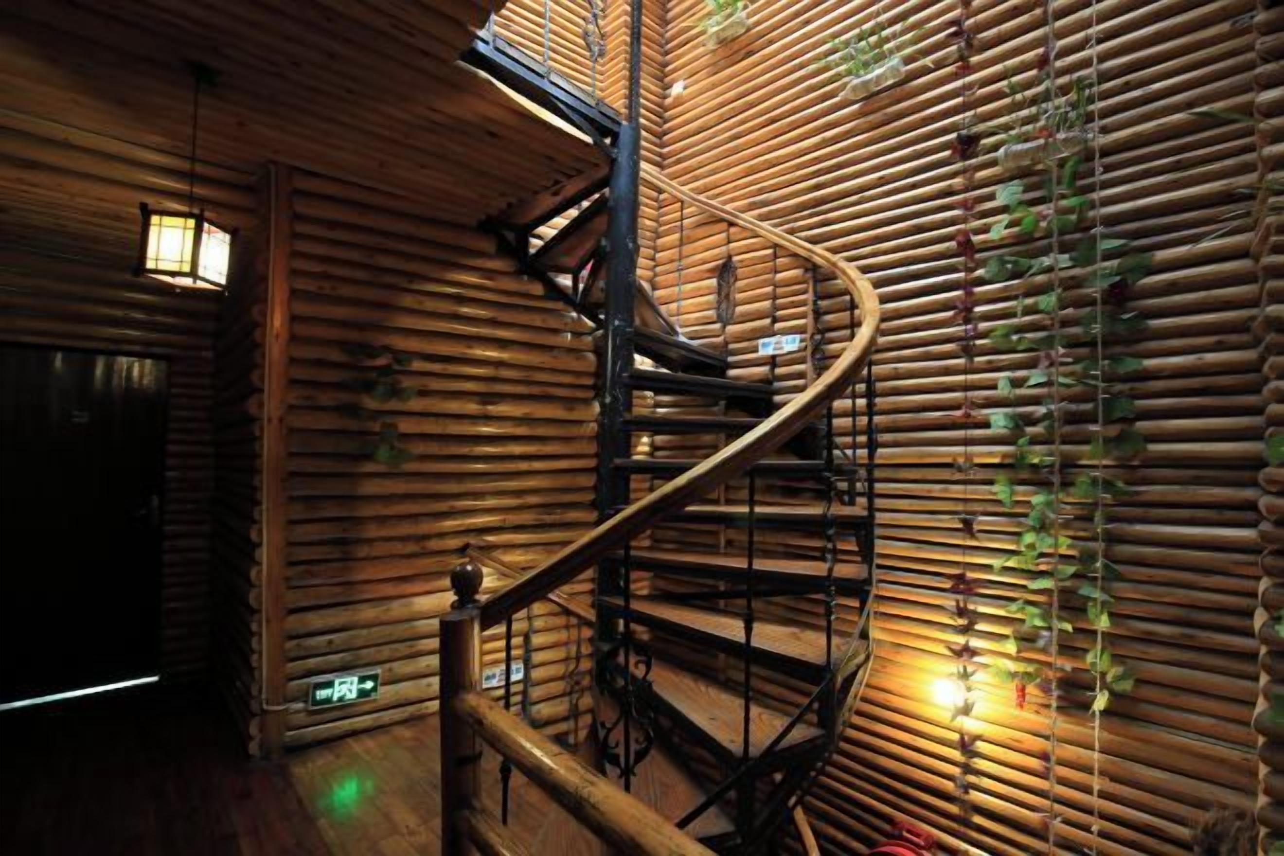 A spiral staircase with a wooden interior and a bamboo wall.