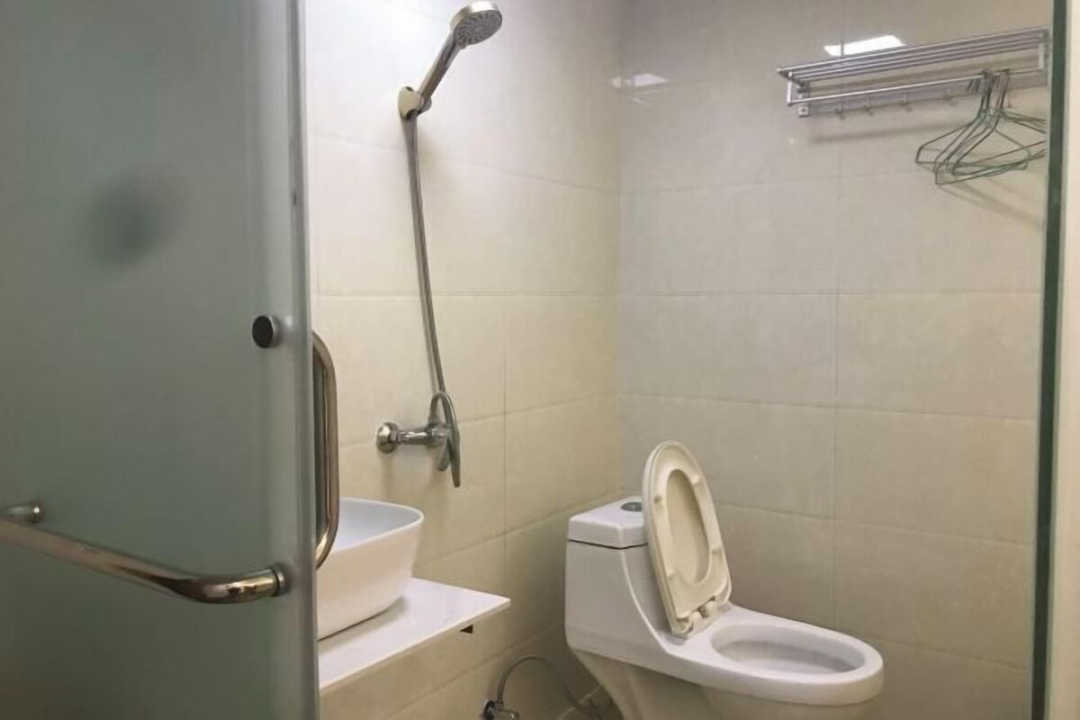 Et badeværelse med toilet, håndvask og bruser.