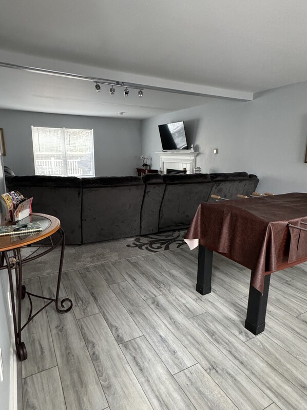 Una habitación con sofá, una mesa con revista, chimenea y televisión.
